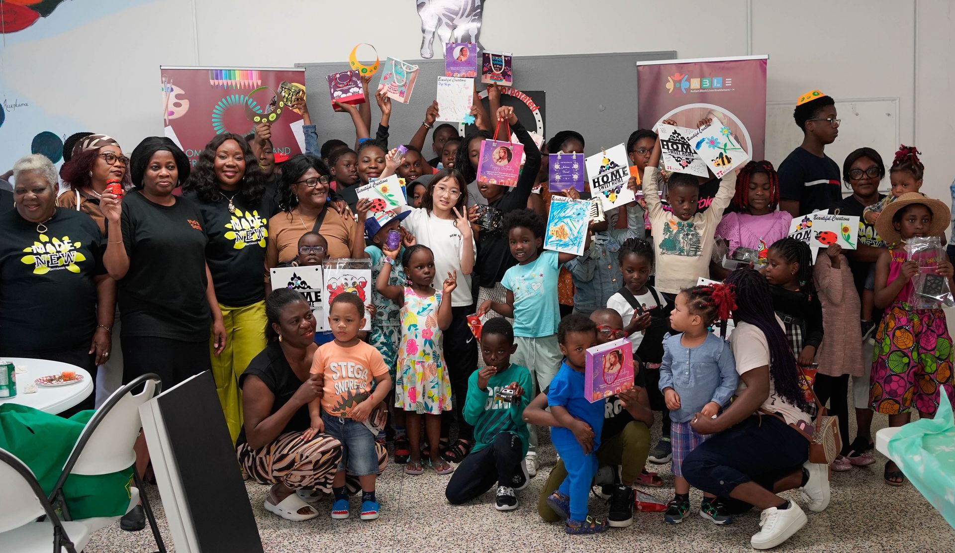 Large group posing with books in a brightly lit room. People are holding up books and smiling.
