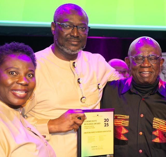 Three people holding an award, smiling at a ceremony. One woman, two men.
