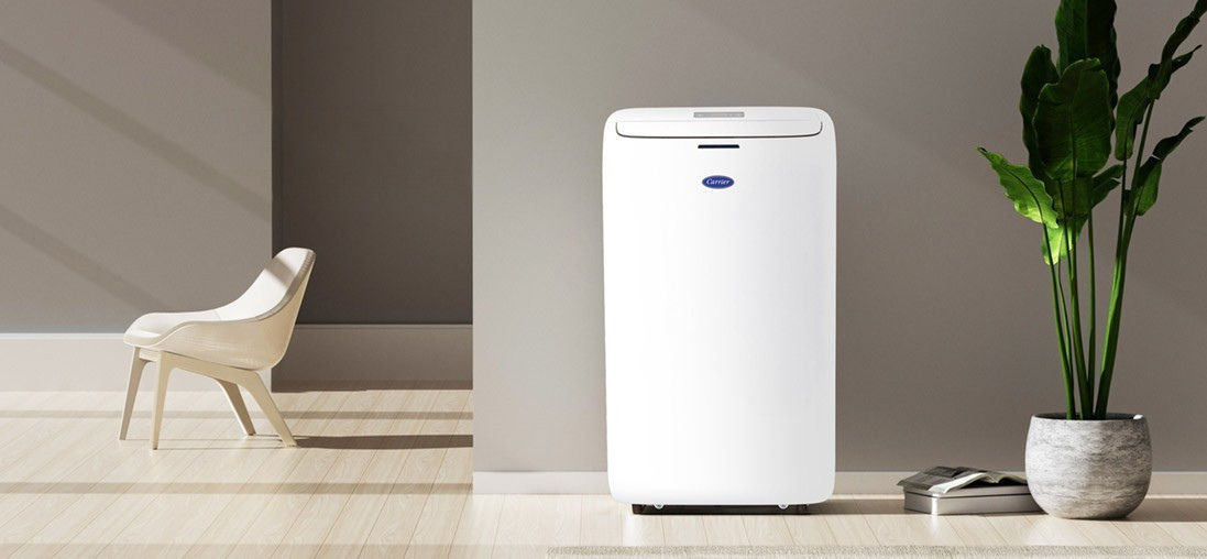 Carrier portable air conditioning unit on floor next to chair and plant