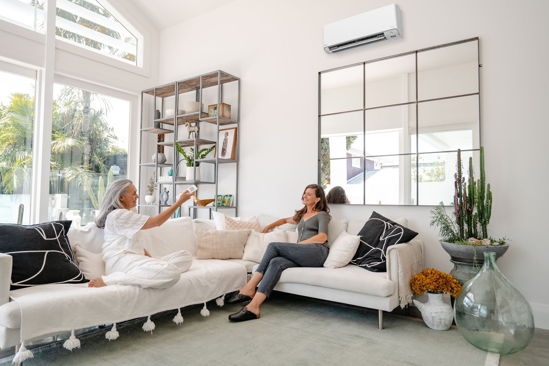 Daikin Alira heat pump in living room with two people using with a remote control