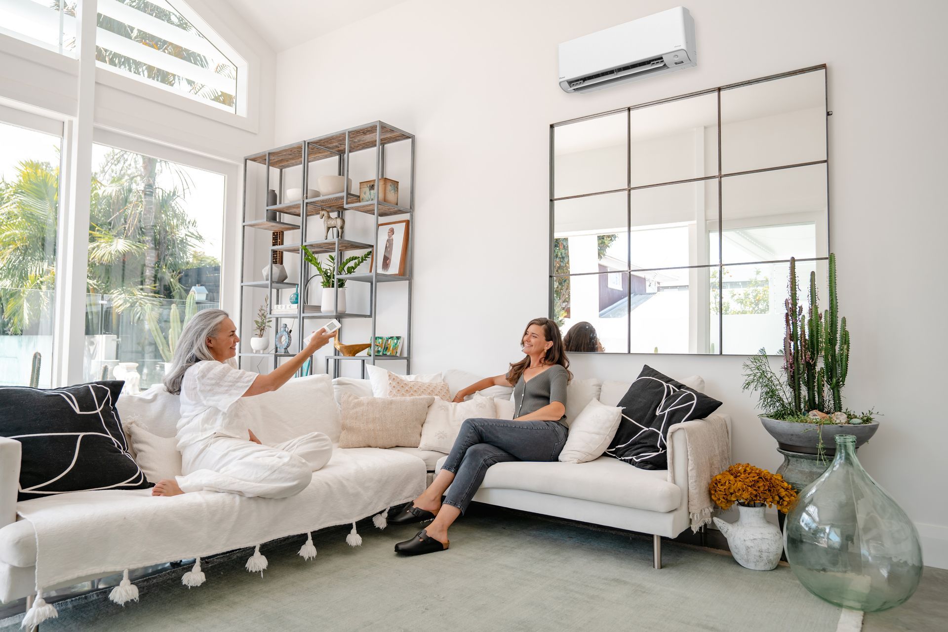 Daikin high wall heat pump on wall in lounge, two ladies sitting on the sofa.