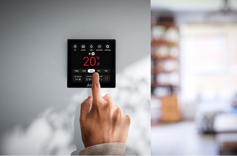 Mitsubishi Electric ZoneIQ control panel on wall with hand touching the screen