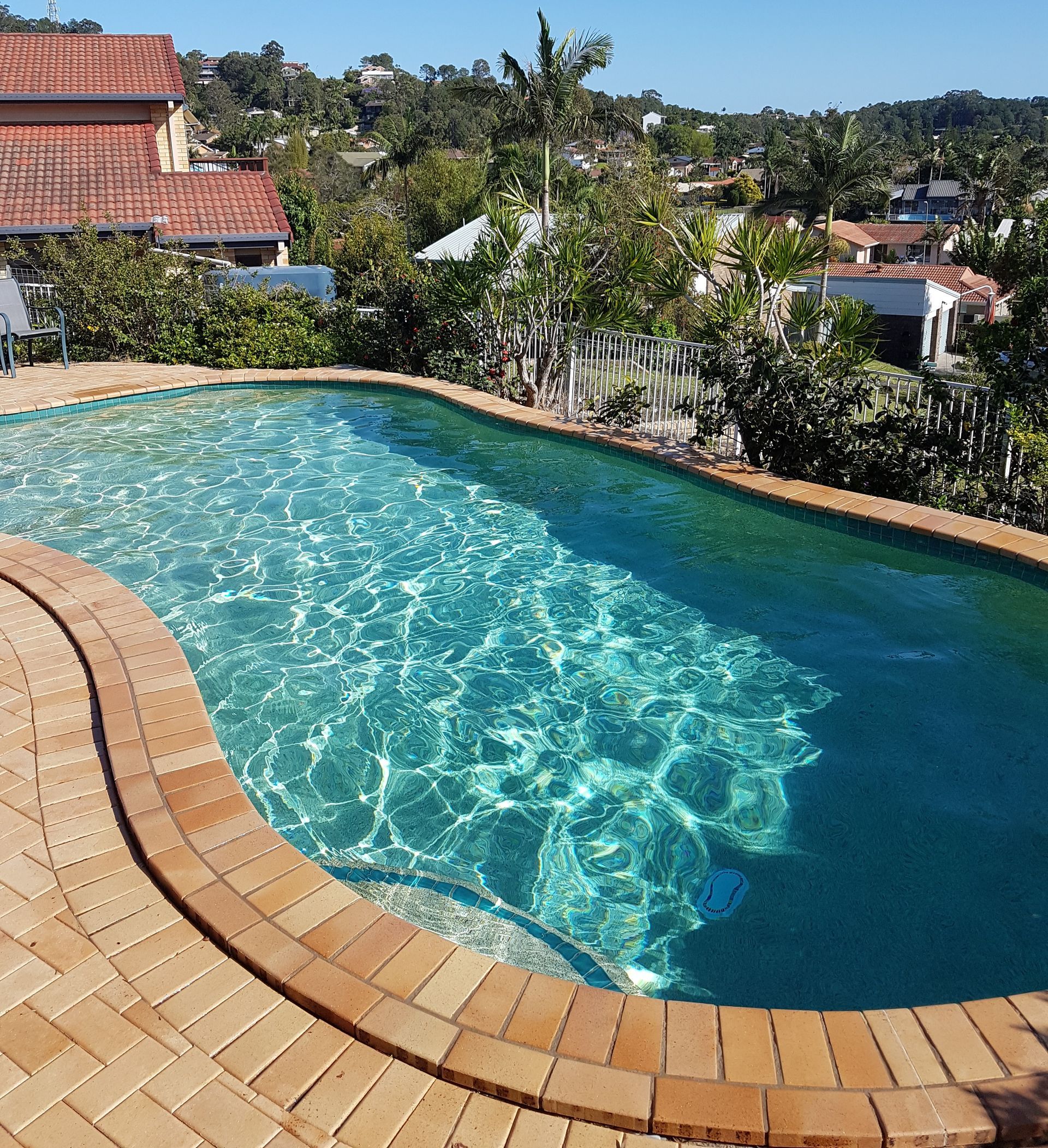 A Person Is Cleaning A Swimming Pool With A Leaf Rake— Kingscliff Pool Shop In Casuarina, NSW
