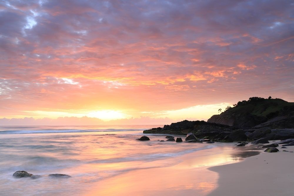 A Beach With A Sunset In The Background And A Cliff In The Foreground — Kingscliff Pool Shop In Cabarita, NSW