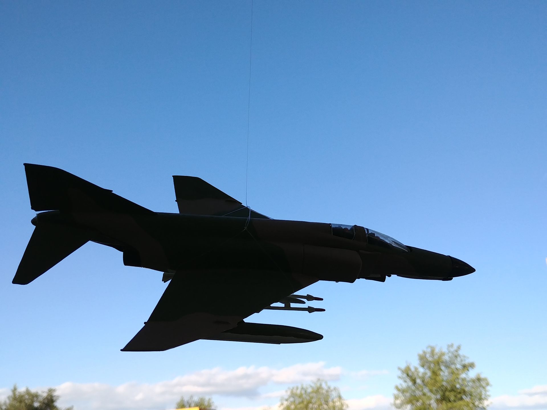 A fighter jet is flying through a blue sky