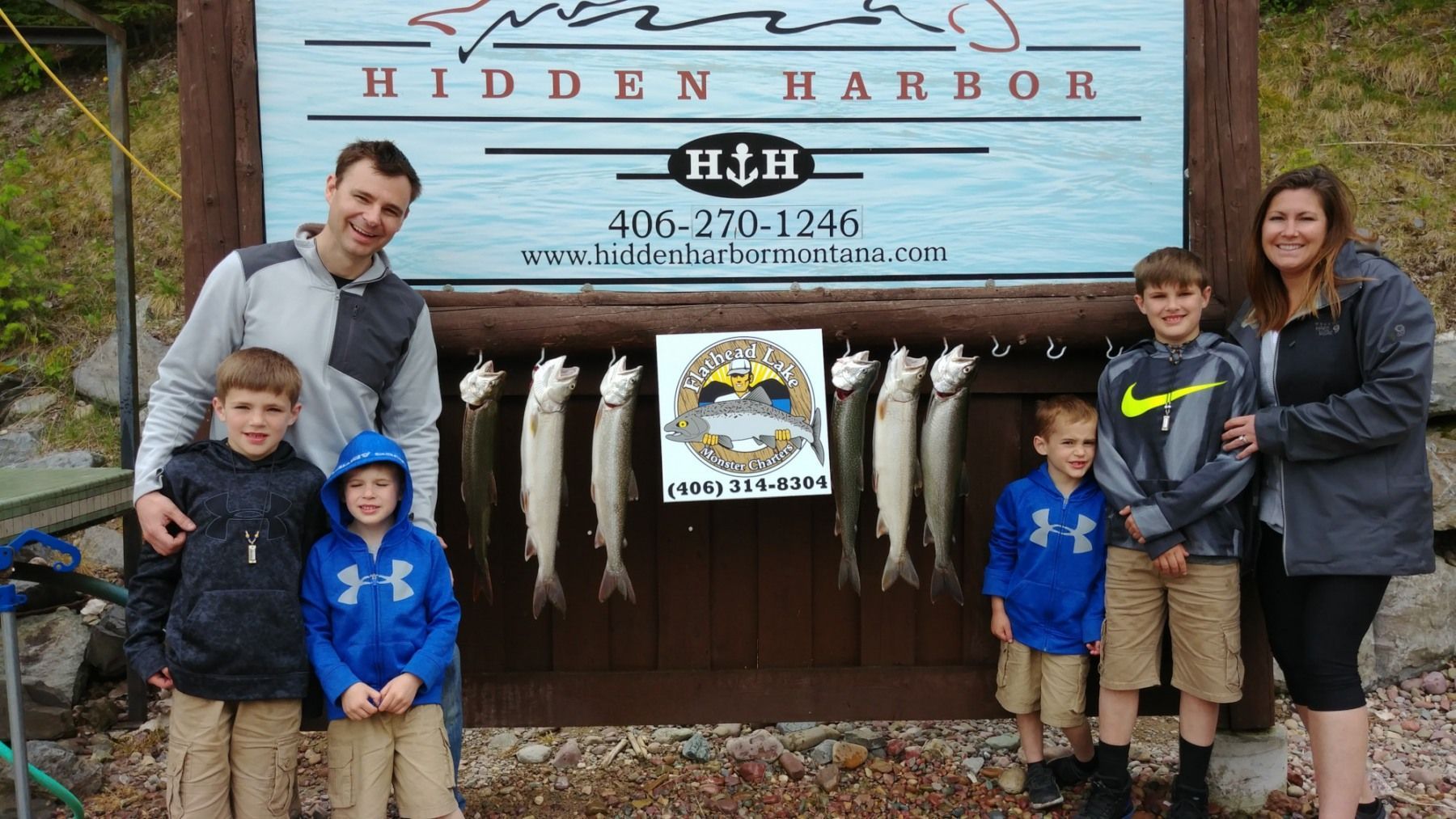 A family standing in front of a sign that says hidden harbor