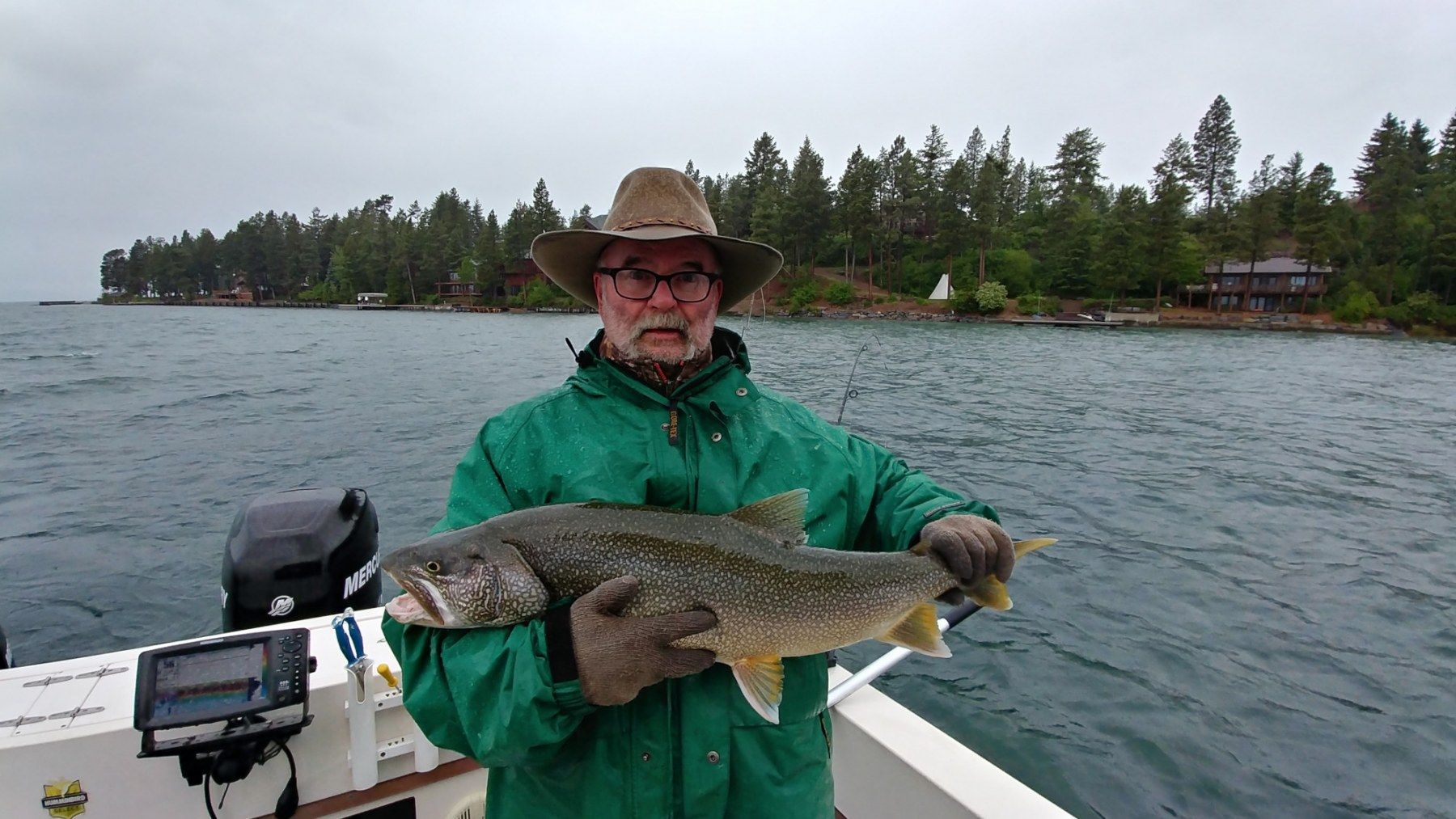 A man is holding a large fish on a boat.