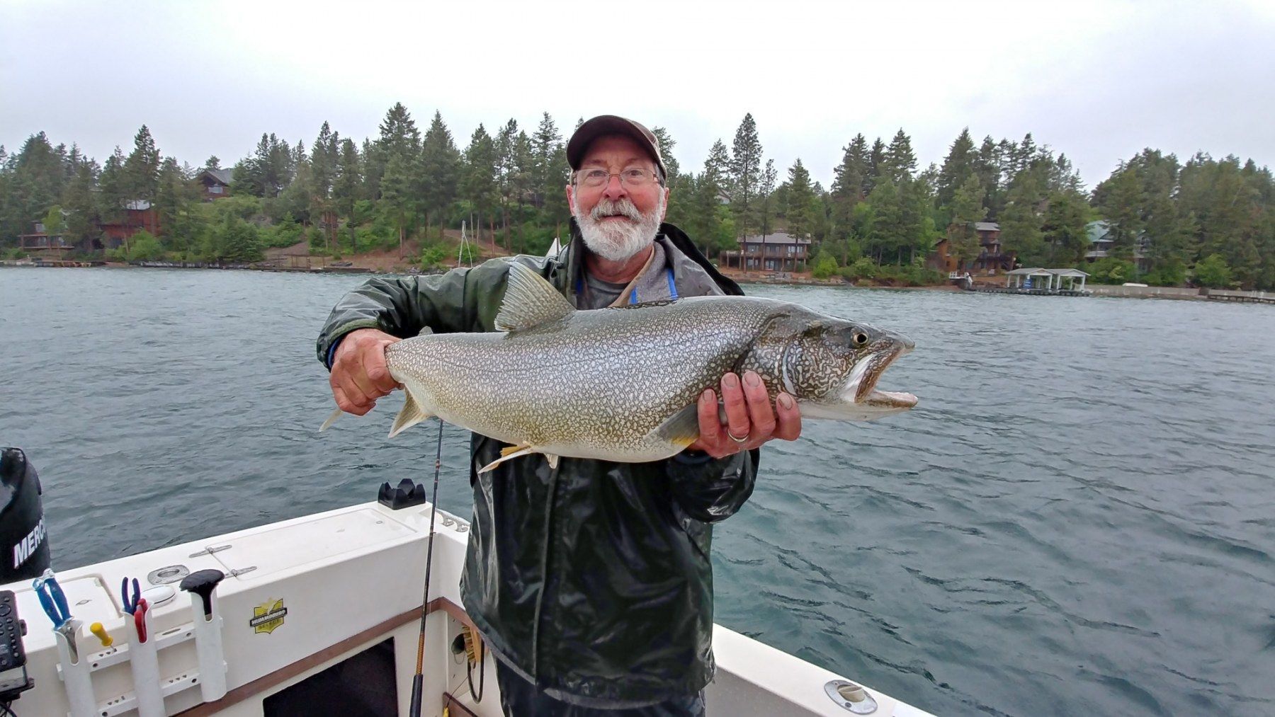 A man is holding a large fish on a boat.