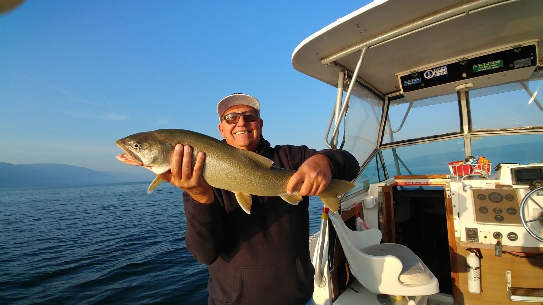A man is holding a large fish on a boat