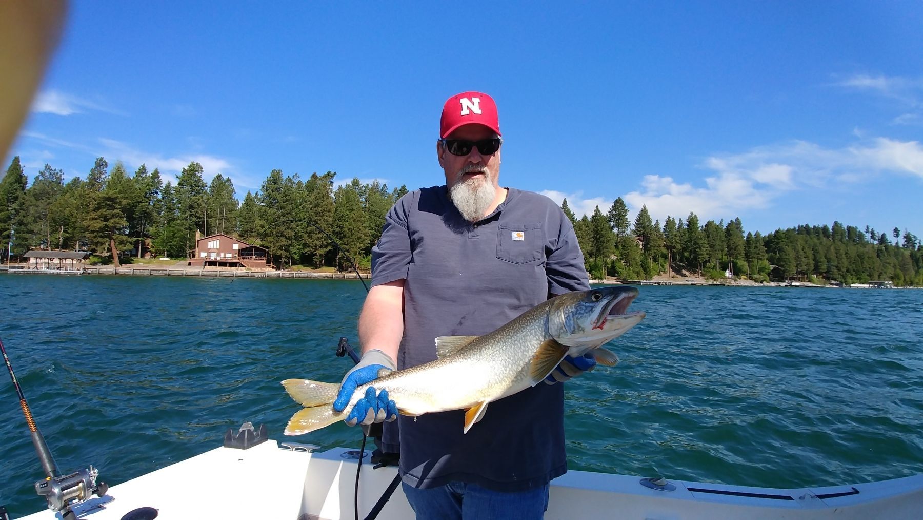 A man is holding a large fish on a boat.
