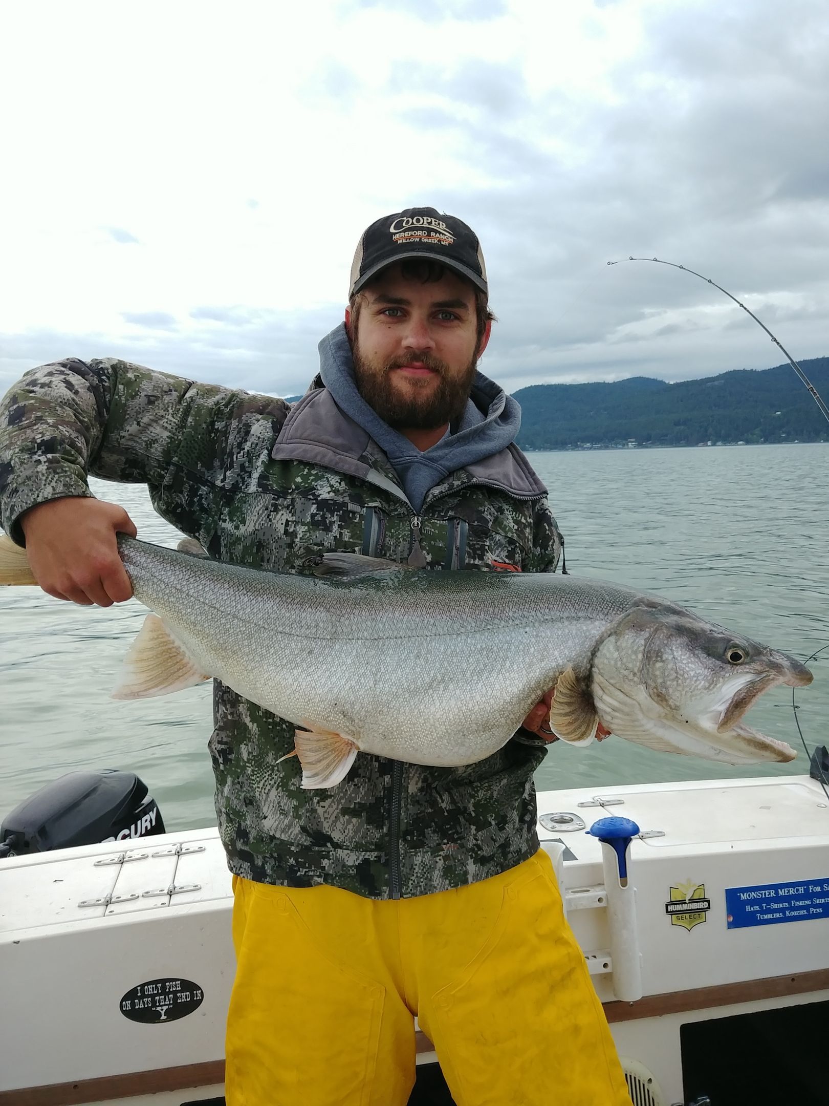 A man is holding a large fish on a boat.