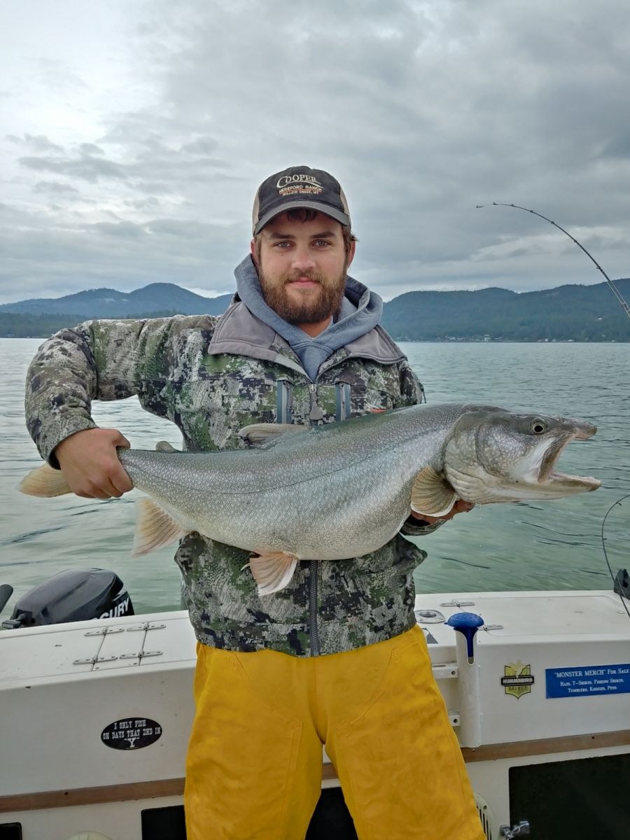 A man is holding a large fish on a boat.