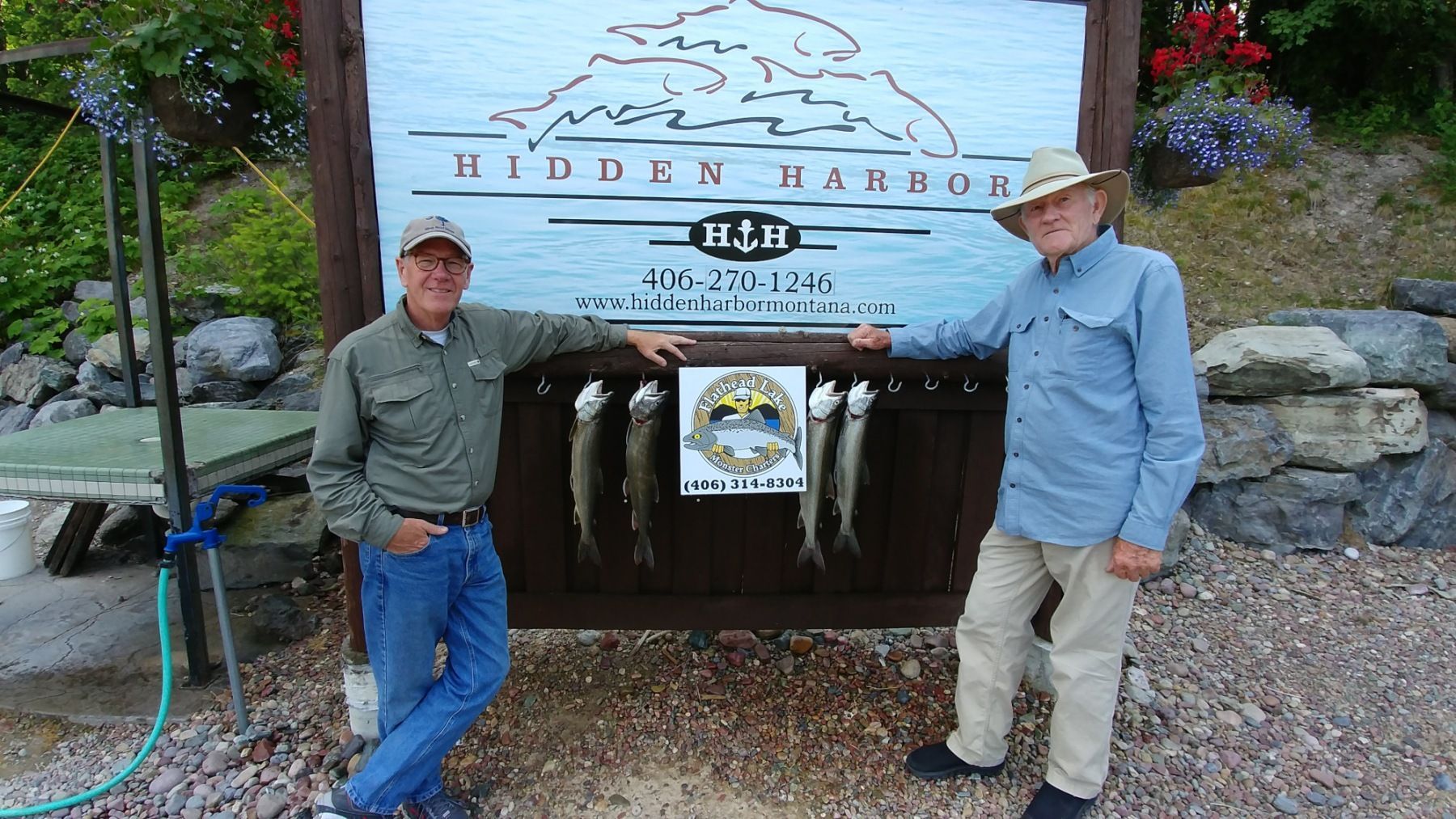 Two men standing in front of a sign that says hidden valley