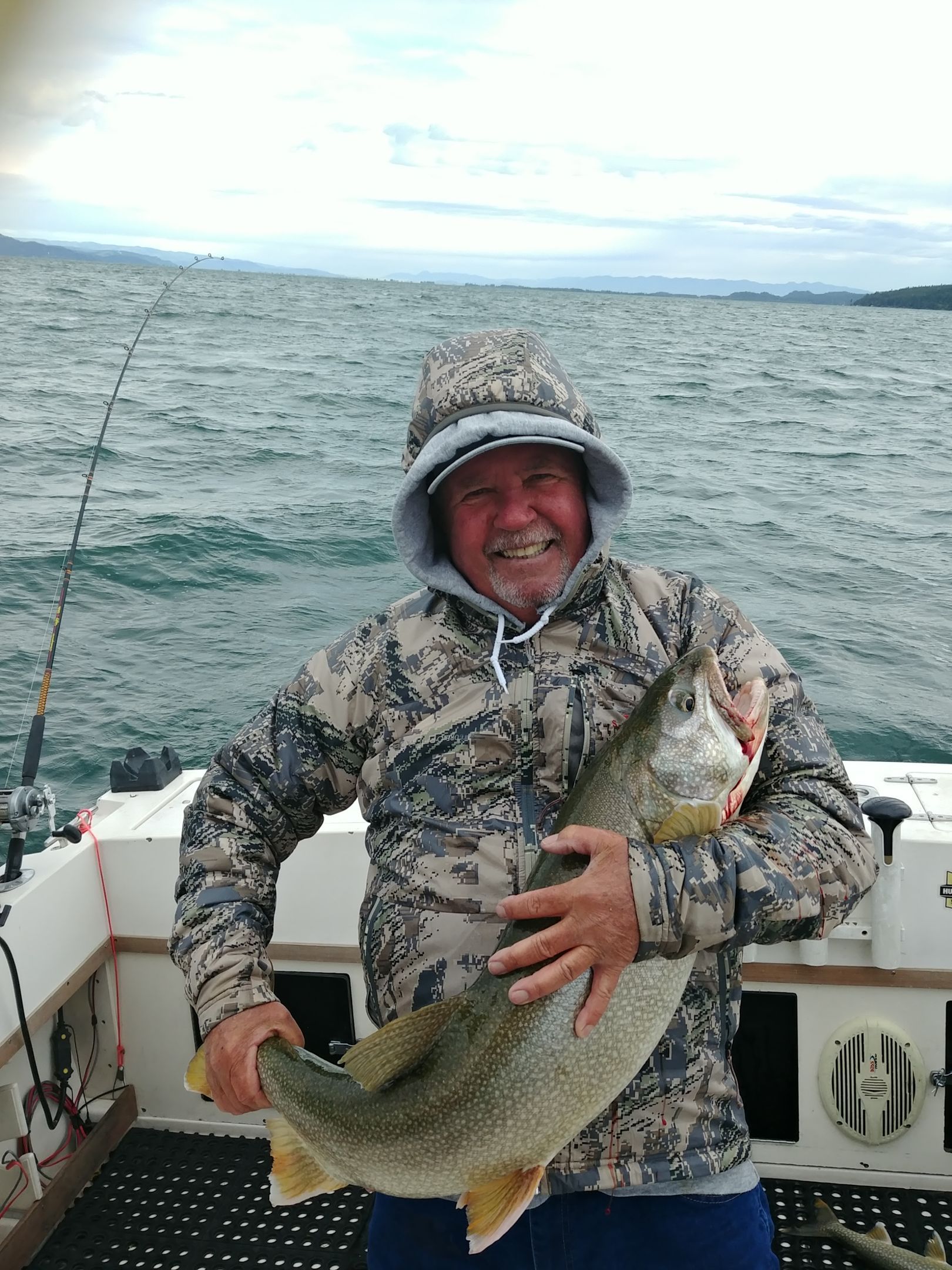 A man is holding a large fish on a boat.