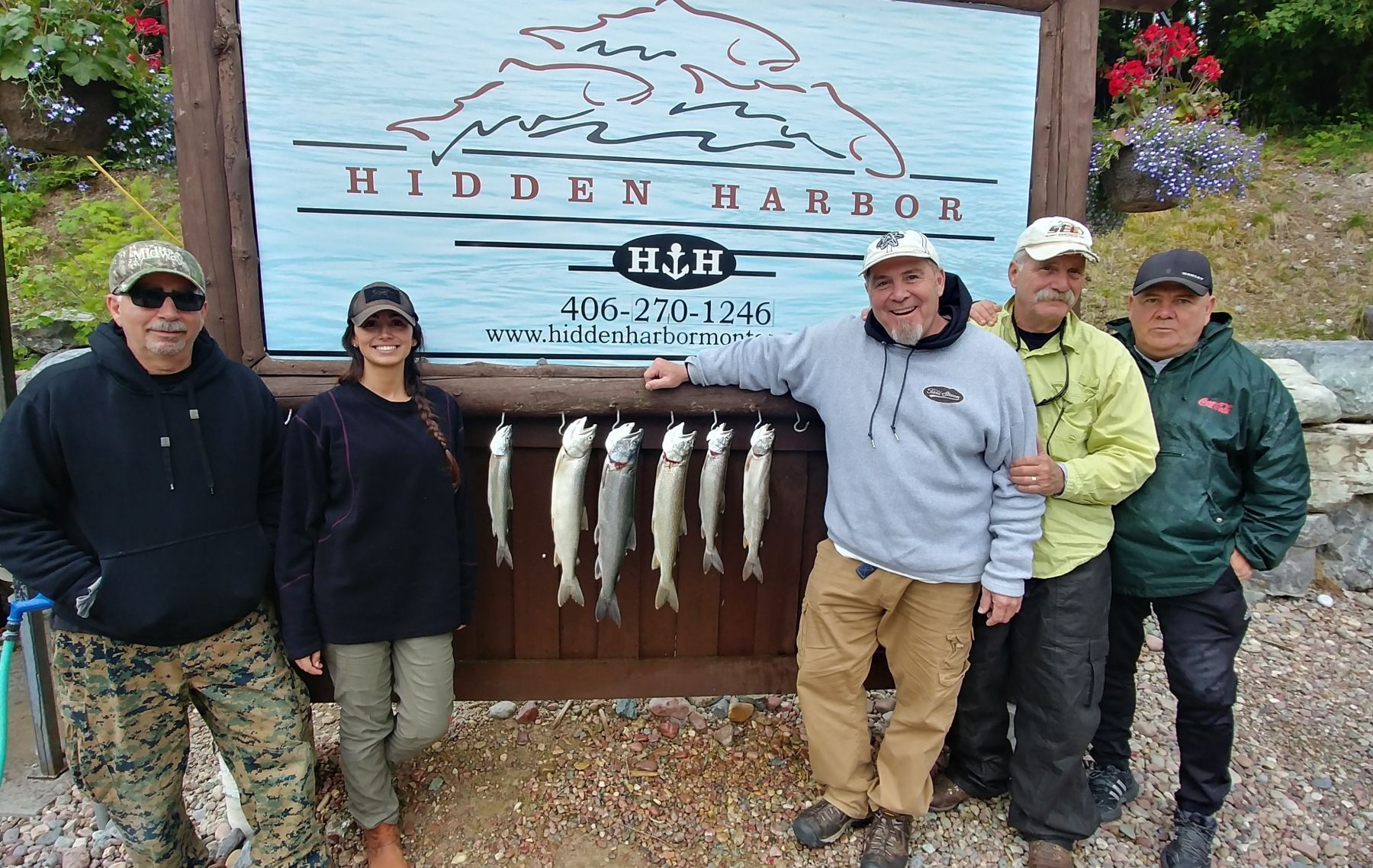 A group of people standing in front of a sign that says hidden harbor