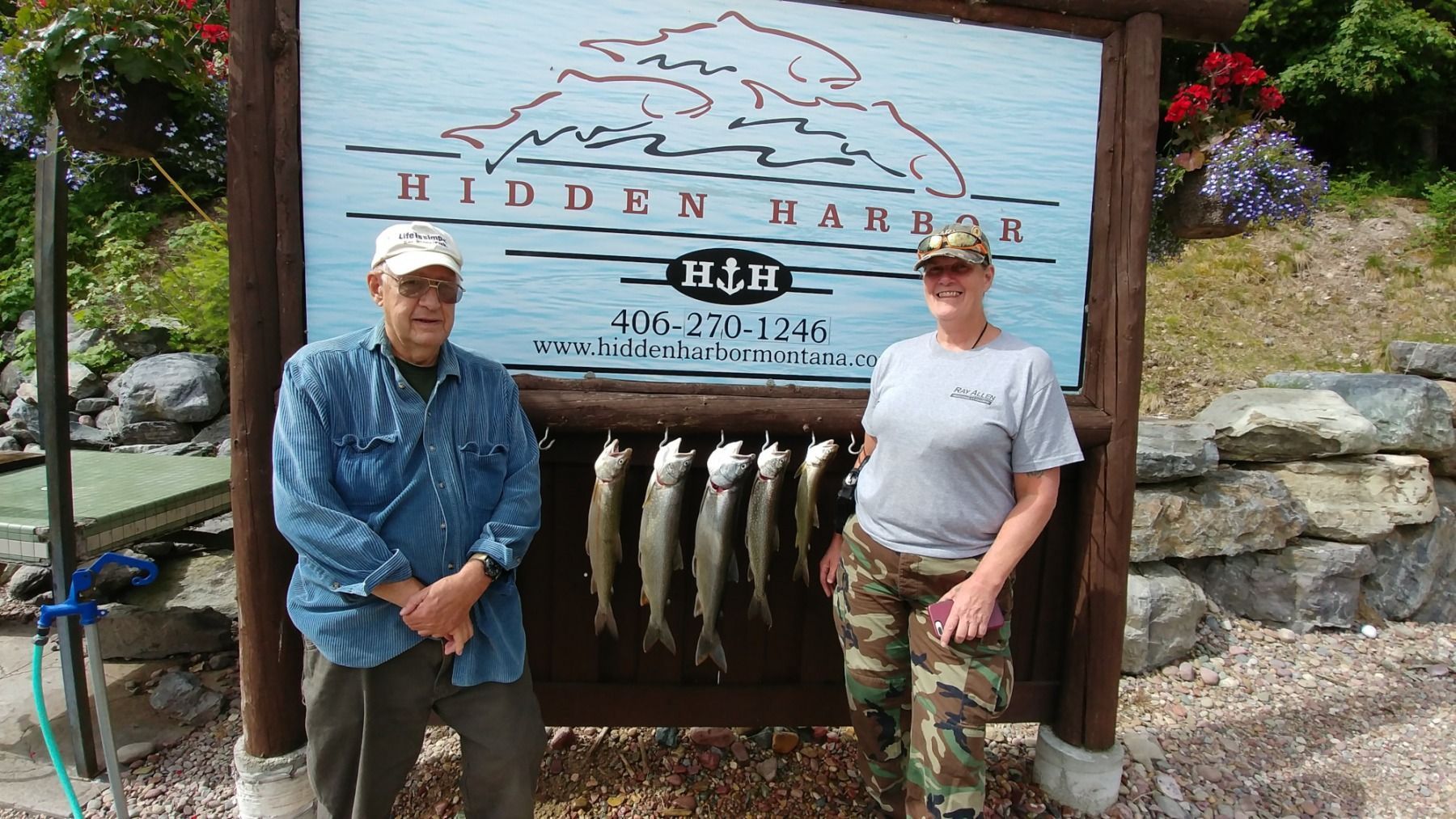 A man and a woman standing in front of a sign that says hidden harbor