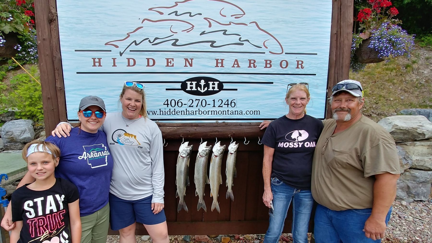 A group of people standing in front of a sign that says hidden harbor