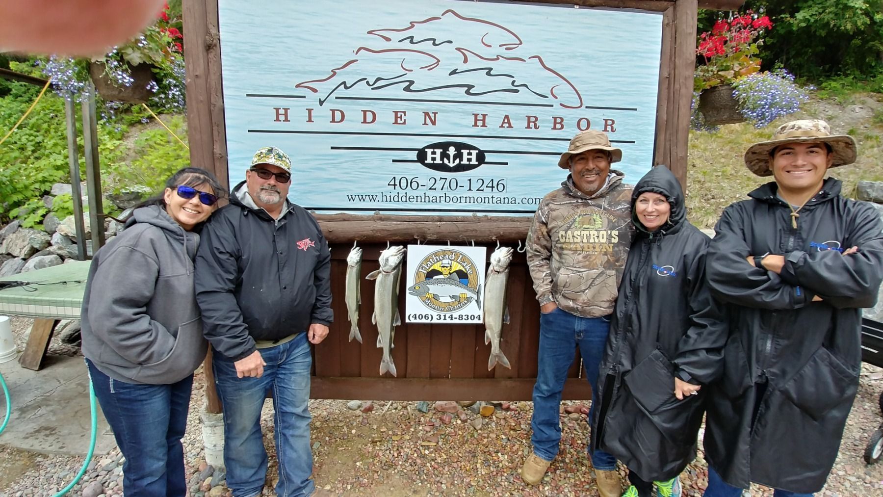 A group of people are standing in front of a sign that says hidden harbor.