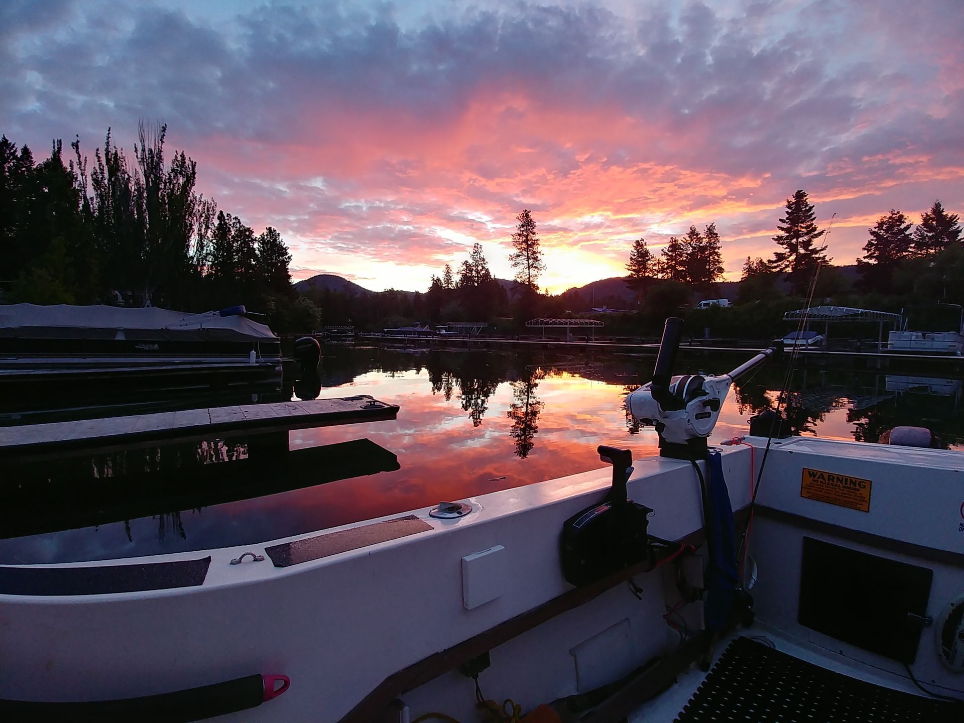 A sunset over a lake with a boat in the foreground