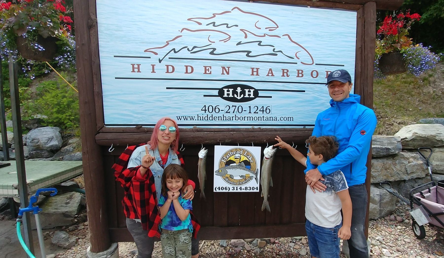 A family is standing in front of a sign that says hidden harbor.