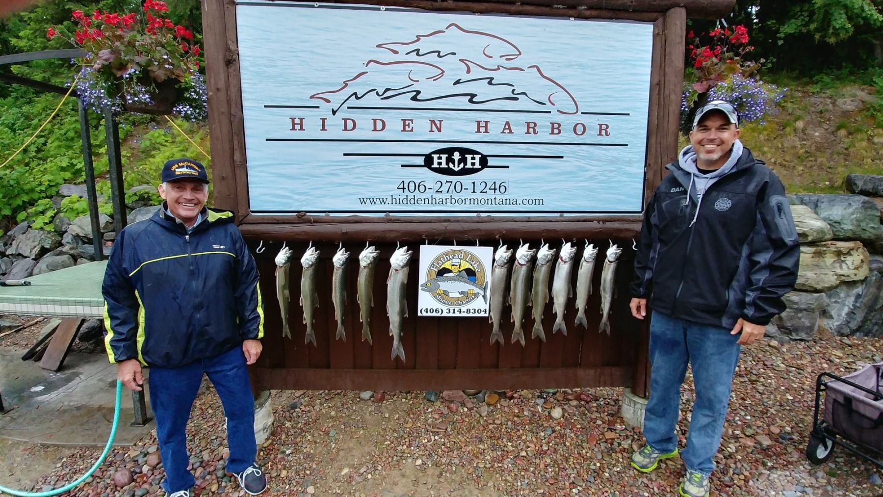 Two men standing in front of a sign that says hidden harbor