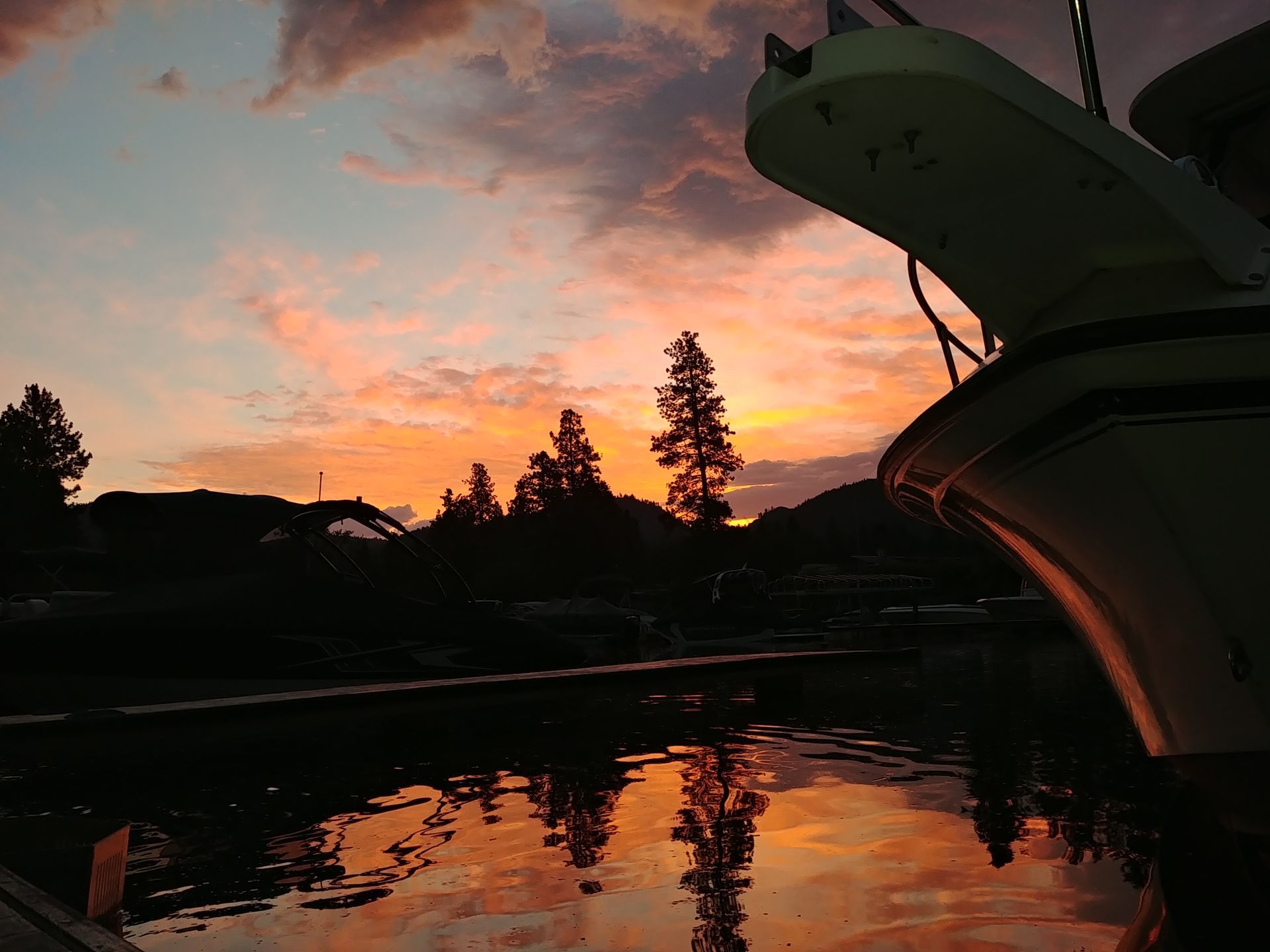 A sunset over a body of water with a boat in the foreground