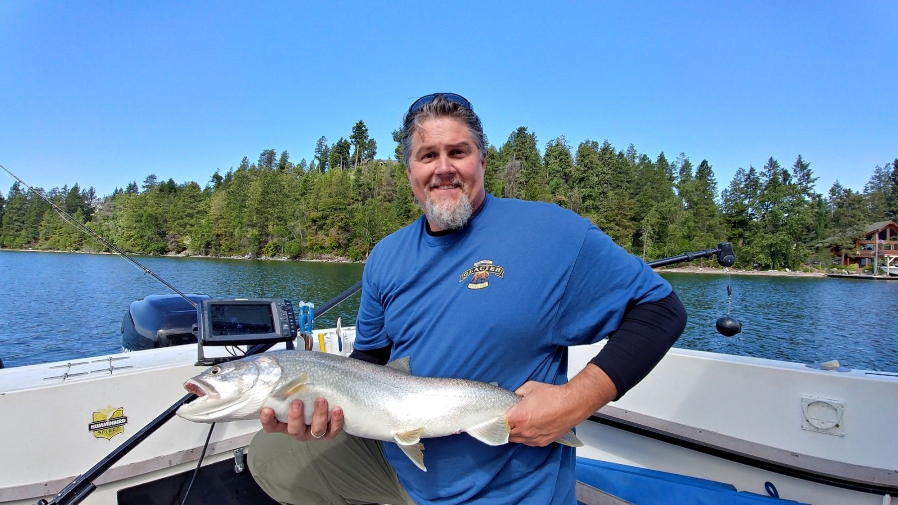 A man is holding a large fish on a boat.