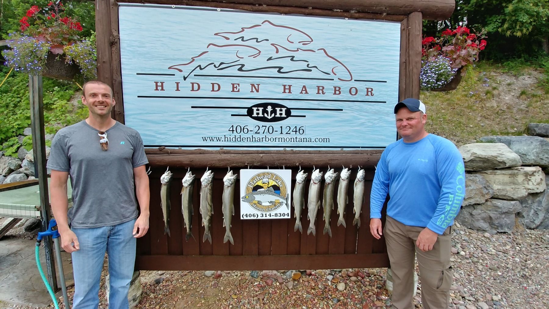 Two men standing in front of a sign that says hidden harbor