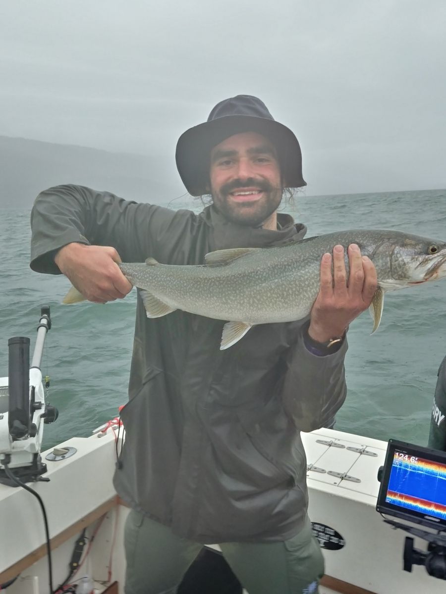 A man on a boat is holding a fish in his hands