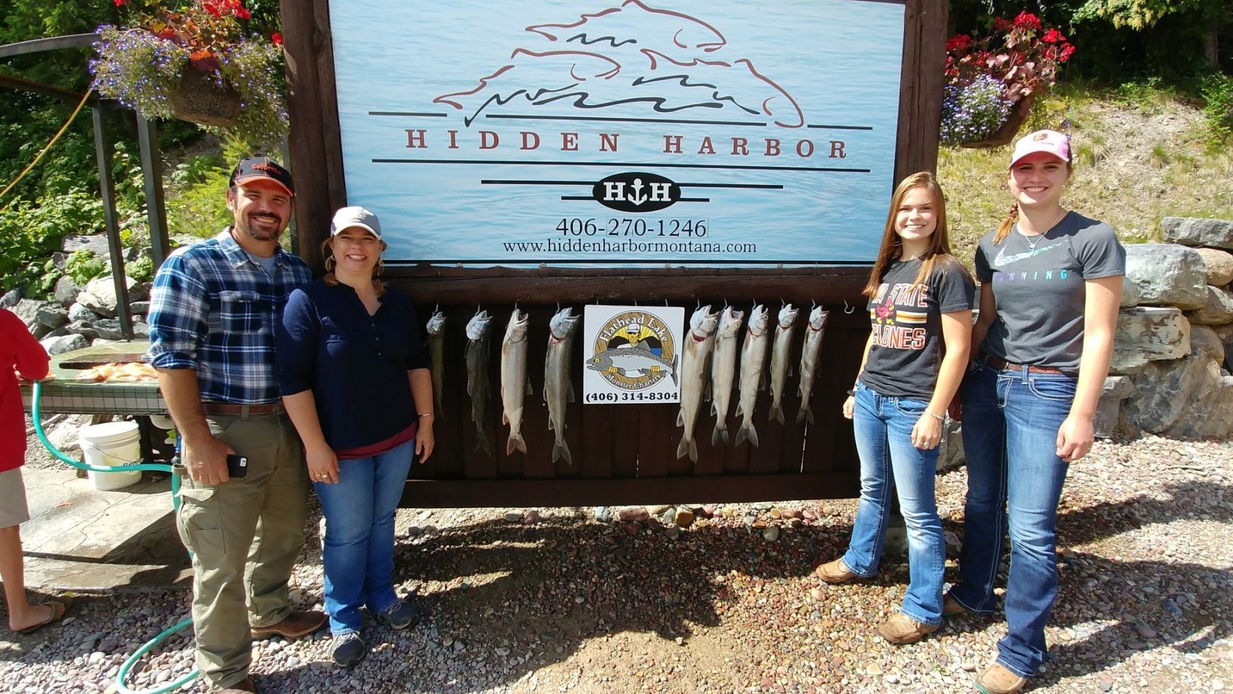 A group of people standing in front of a sign that says hidden kanoa