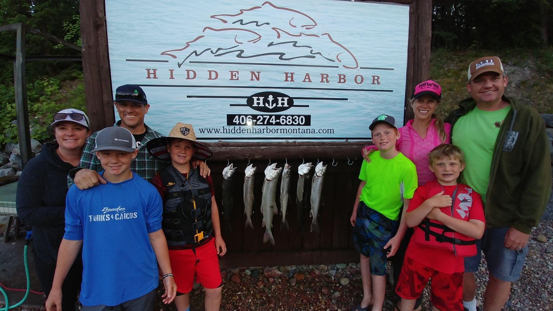 A group of people standing in front of a sign that says hidden harbor