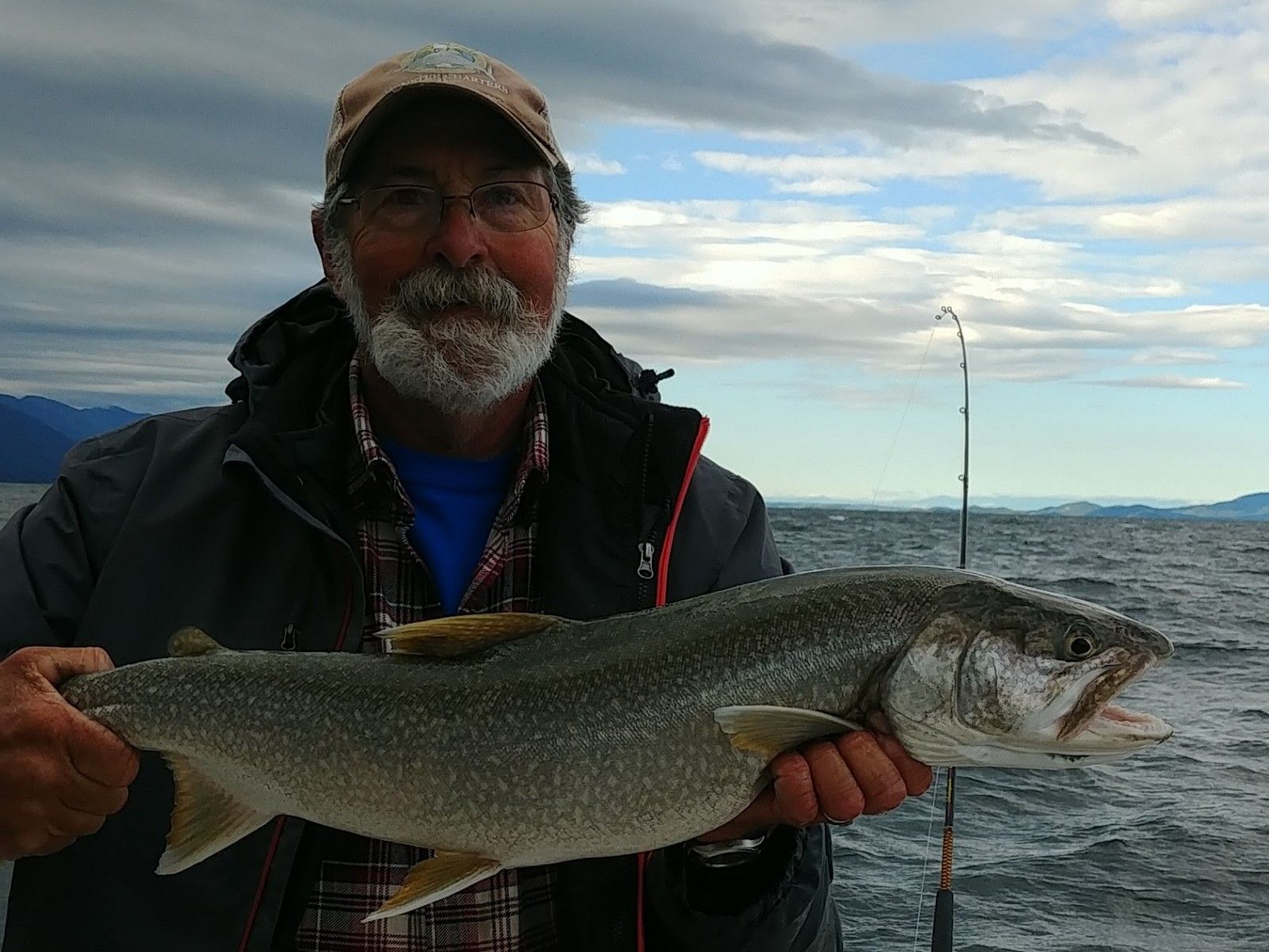 A man is holding a large fish in his hands