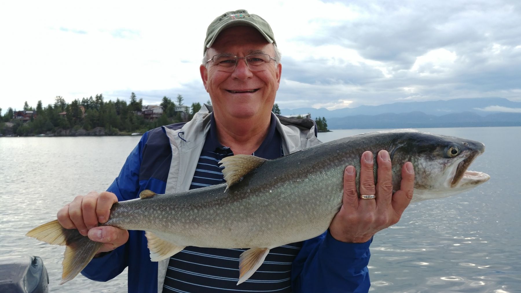 A man is holding a large fish in his hands