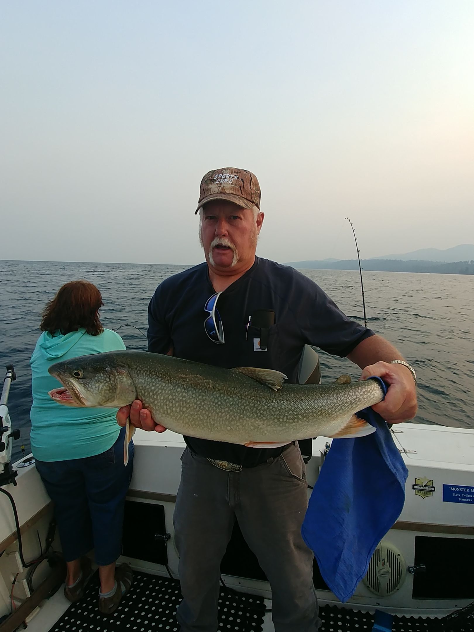 A man is holding a large fish on a boat.