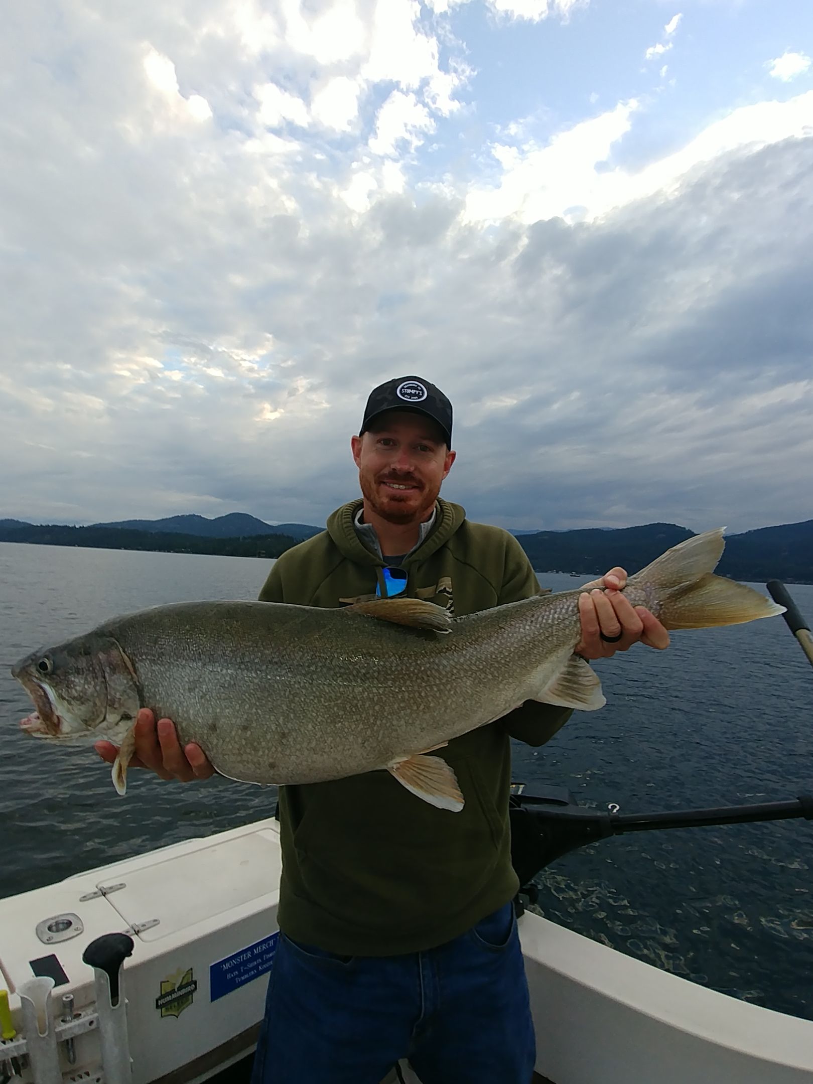 A man is holding a large fish on a boat.