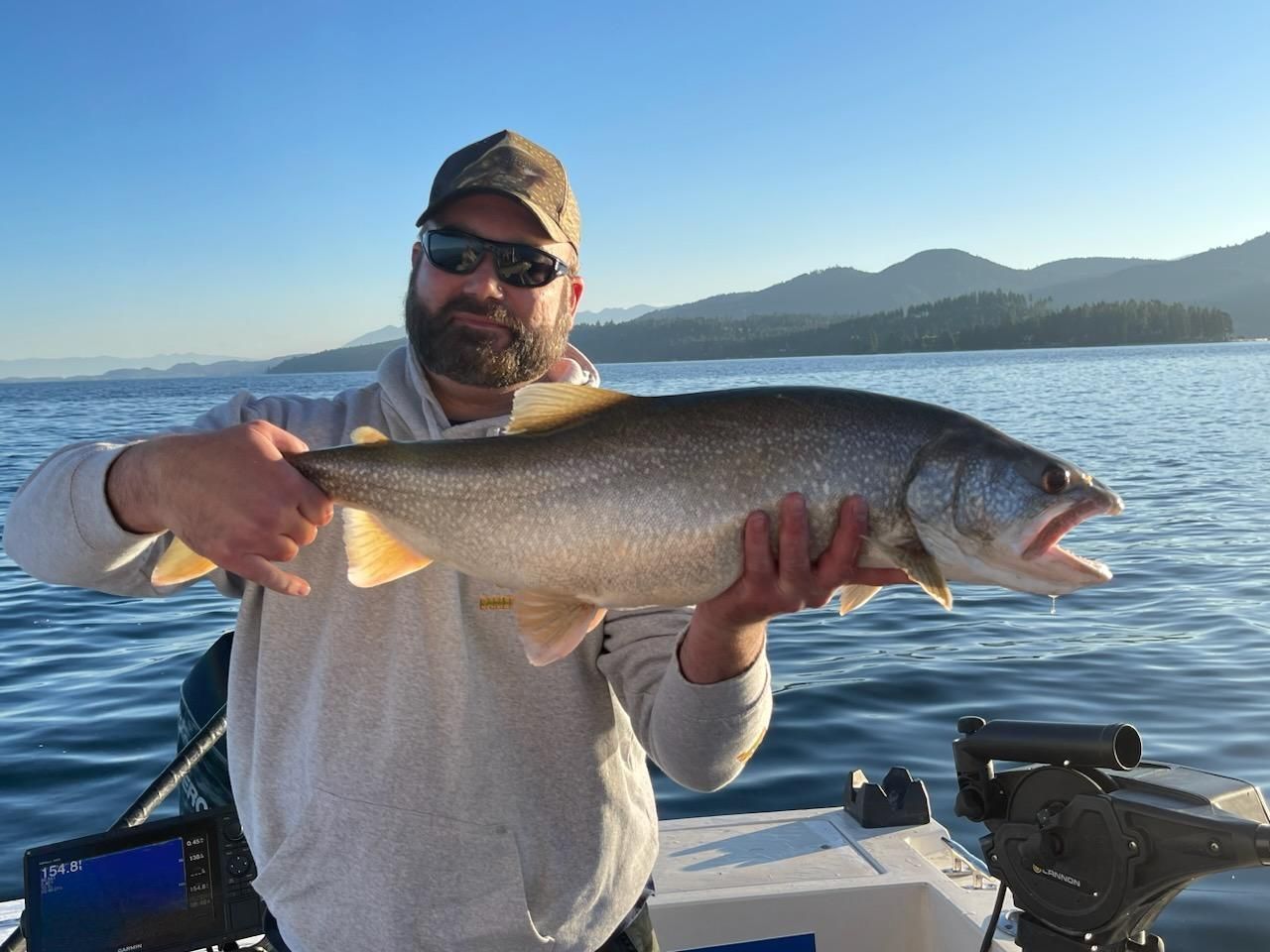 A man is holding a large fish on a boat.