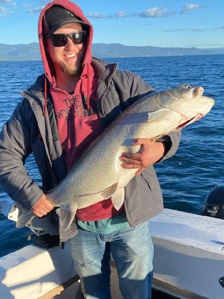 A man is holding a large fish on a boat