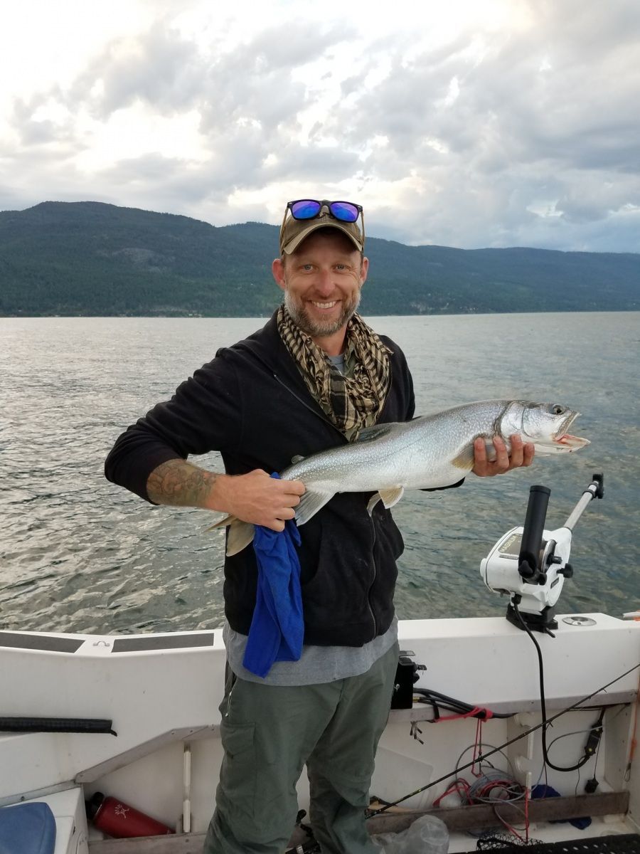 A man is holding a large fish on a boat