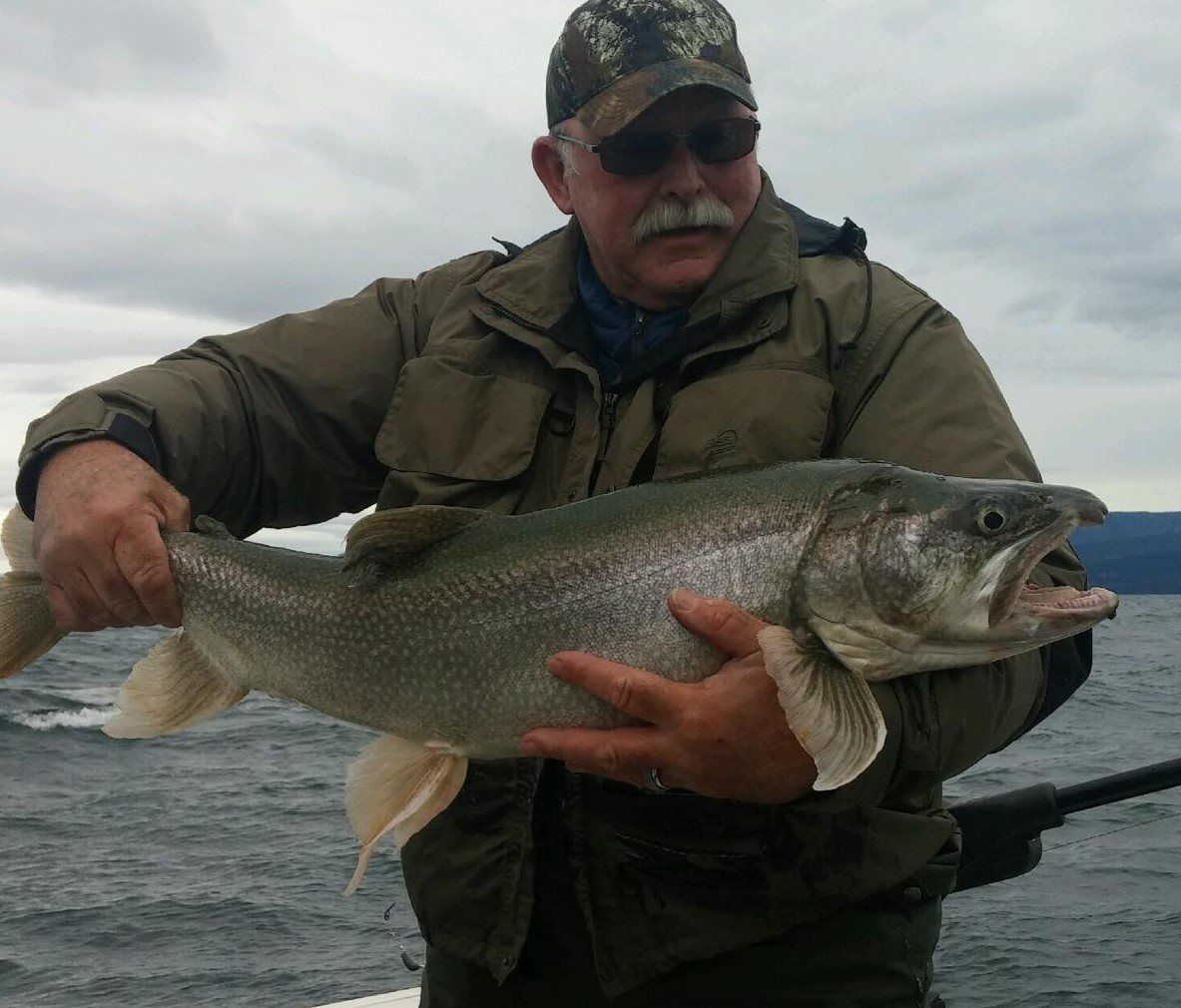 A man is holding a large fish in his hands