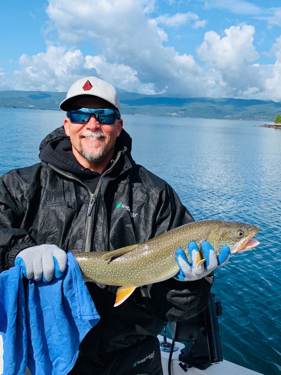A man is holding a fish in his hands on a boat.