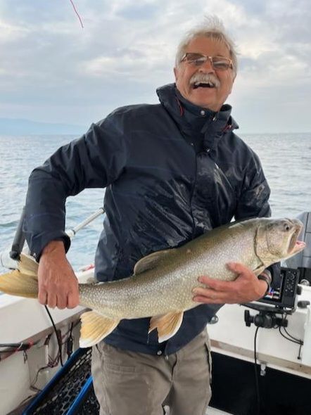 A man is holding a large fish on a boat