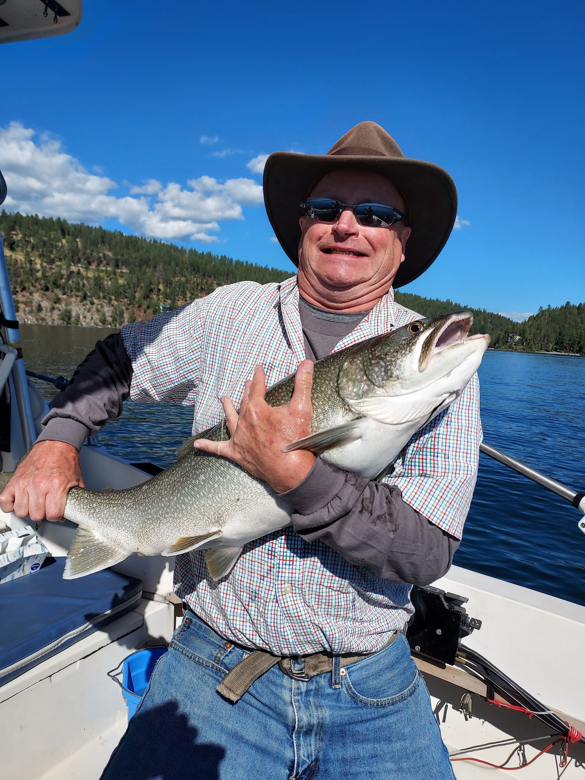 A man is holding a large fish on a boat.
