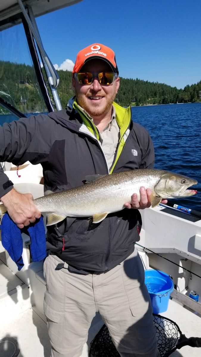 A man is holding a large fish on a boat.