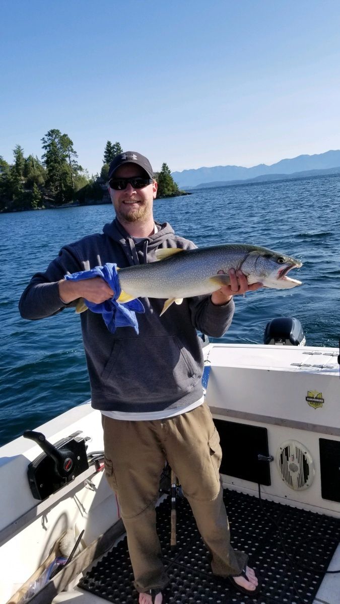 A man is holding a large fish on a boat.