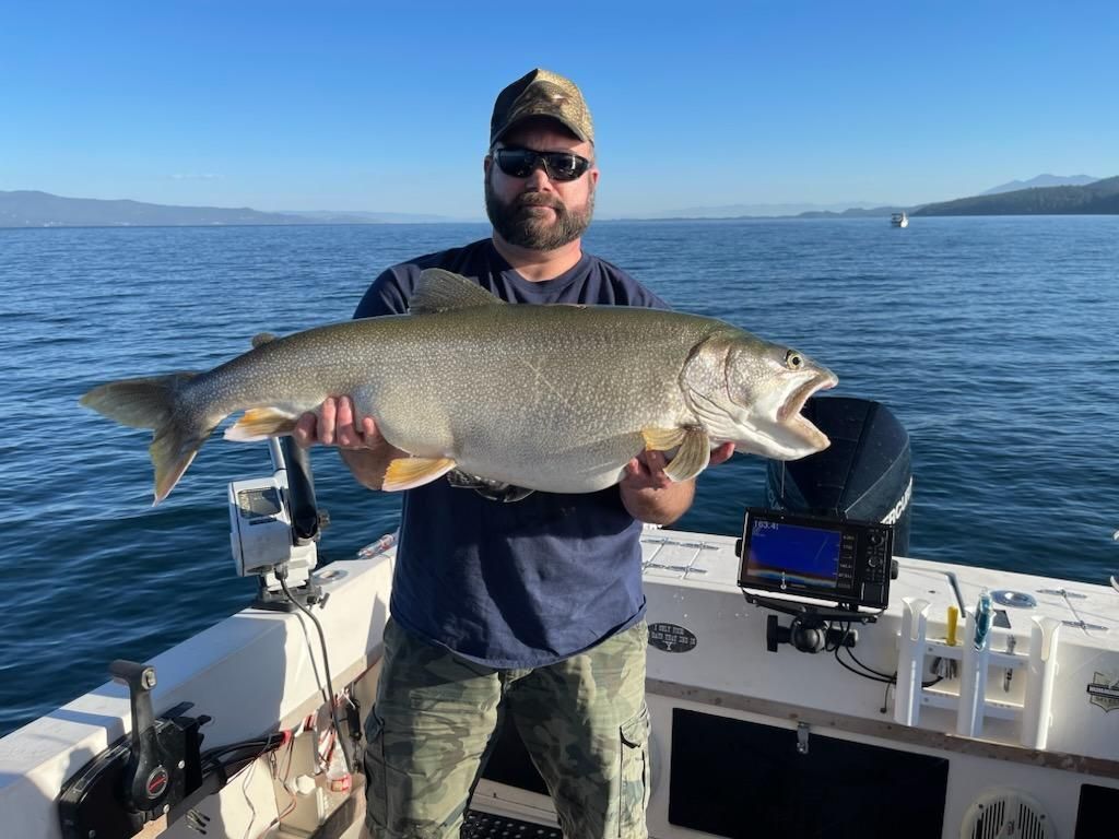 A man is holding a large fish on a boat.
