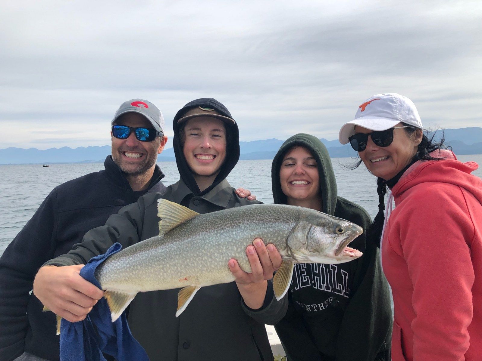 A group of people are standing next to each other holding a large fish.