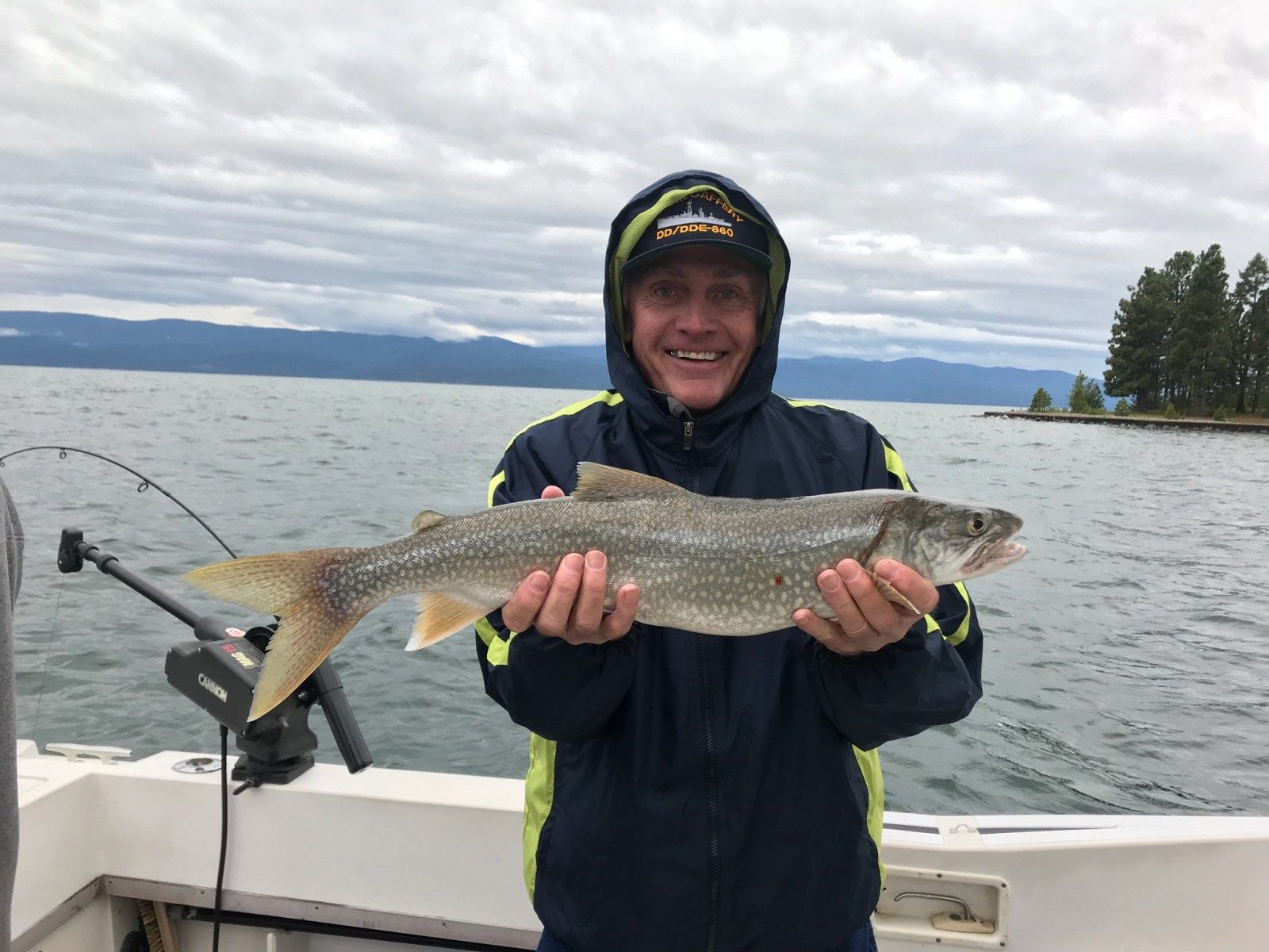 A man is holding a large fish on a boat.