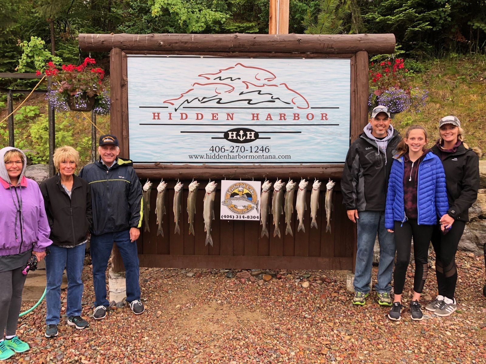A group of people standing in front of a sign that says hidden harbor.