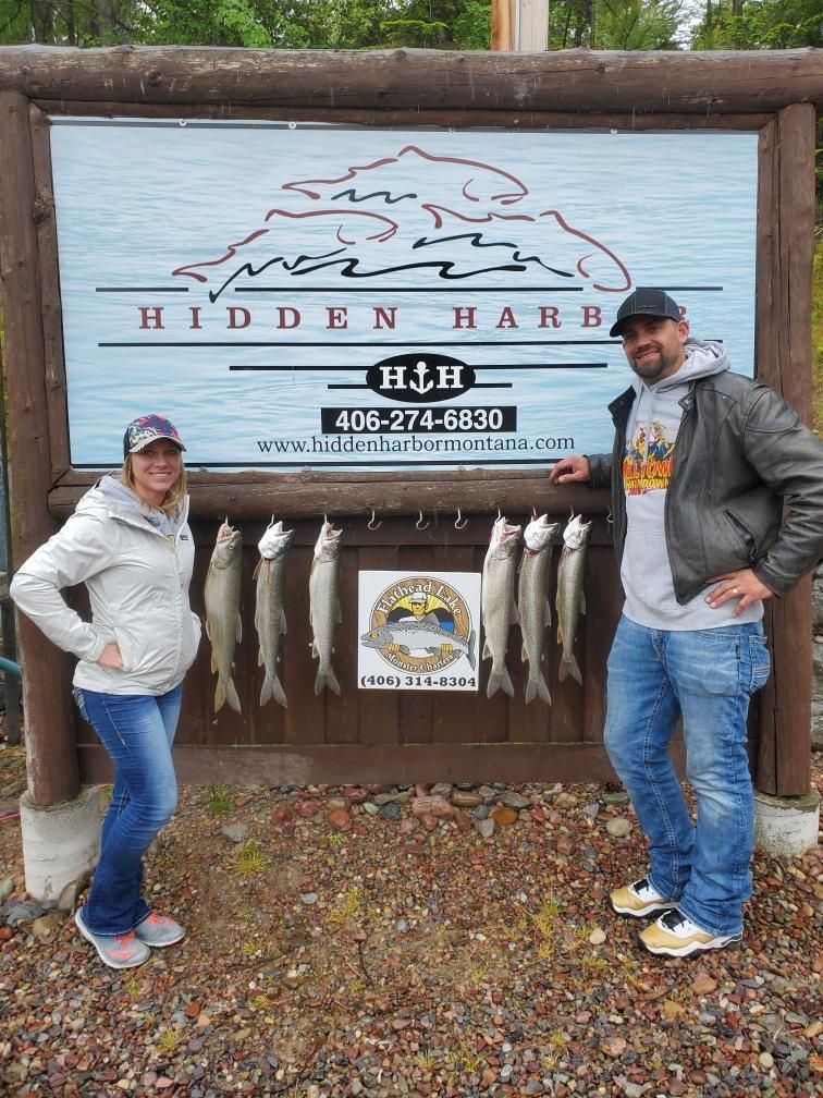 A man and a woman are standing in front of a sign with fish on it.