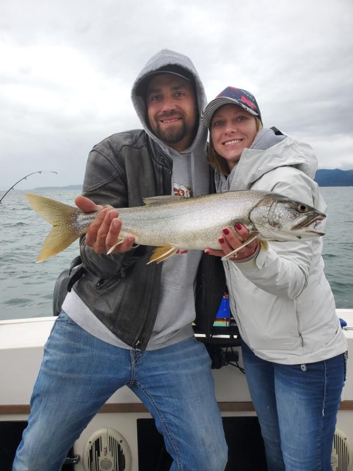 A man and a woman are holding a large fish on a boat.